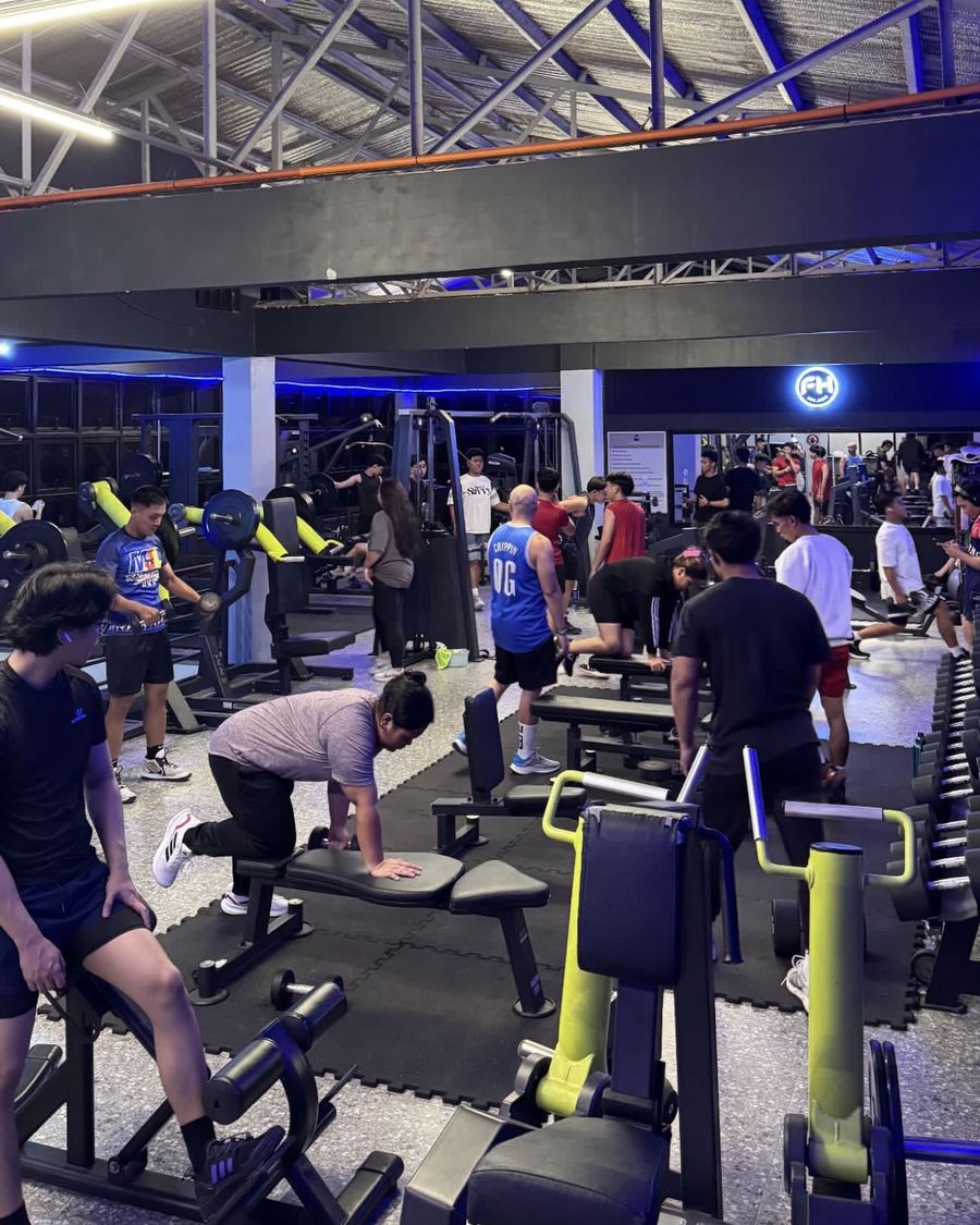 Members training on benches and machines during a busy evening